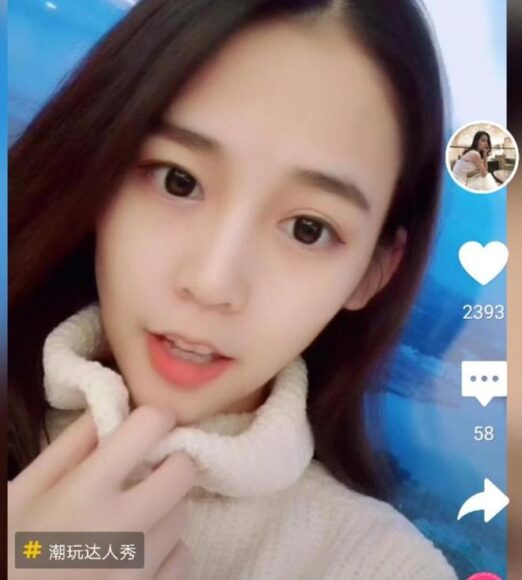 抖音女主播微笑自拍,背景藍色.