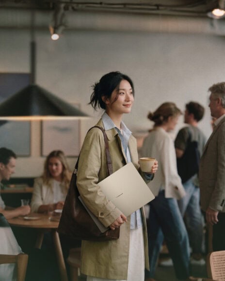 年輕女性在咖啡店中微笑拿著咖啡.