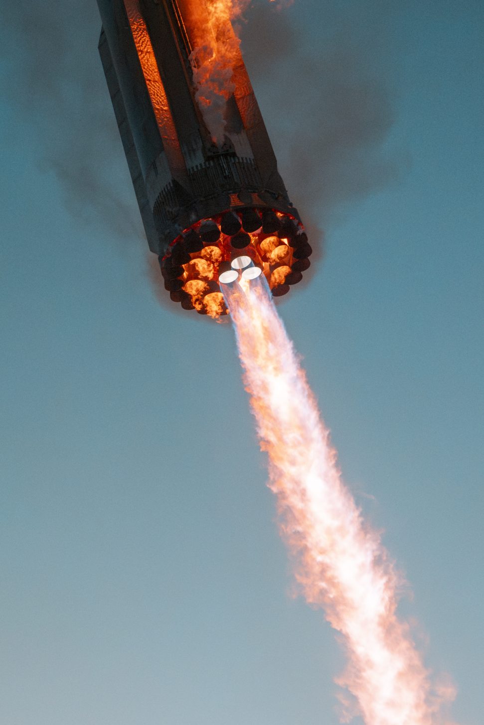 Image shows SpaceX Starship Super Heavy Booster's engines red from the heat during the landing burn in Flight 5 test