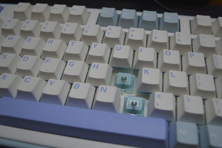 Mechanical keyboard showing exposed blue switches.