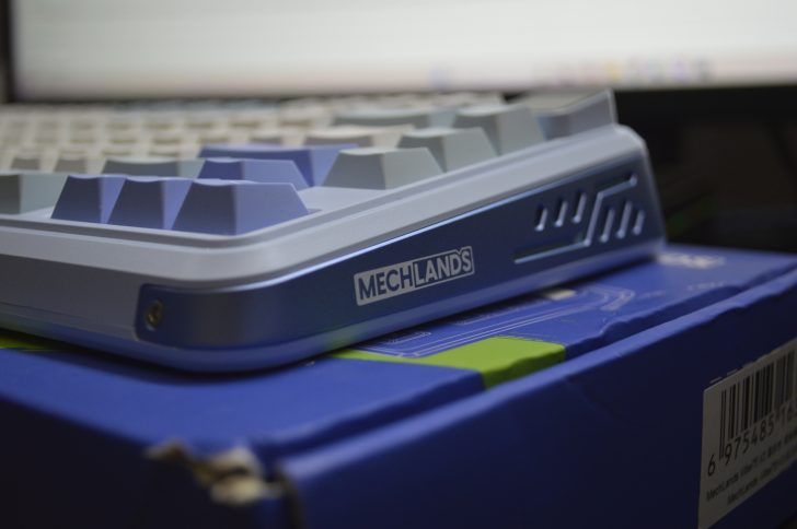 Mechanical keyboard close-up on blue box, featuring Mechlands logo.