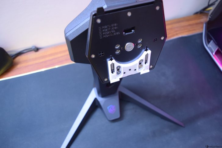 Monitor stand with adjustable bracket on a desk.