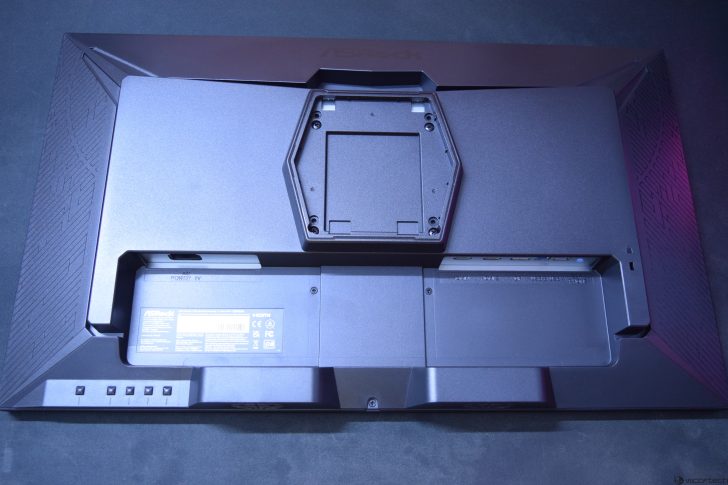 Back of a computer monitor showing ports and mount bracket against a dark background.