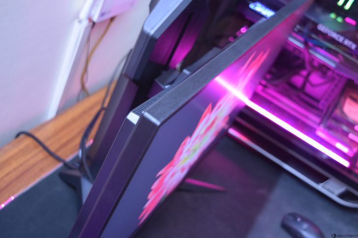 Dual monitors on a desk setup with ambient pink lighting.
