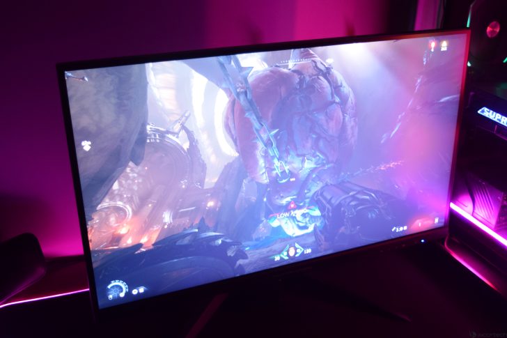 Gaming monitor displaying an intense action scene with vibrant neon lighting.