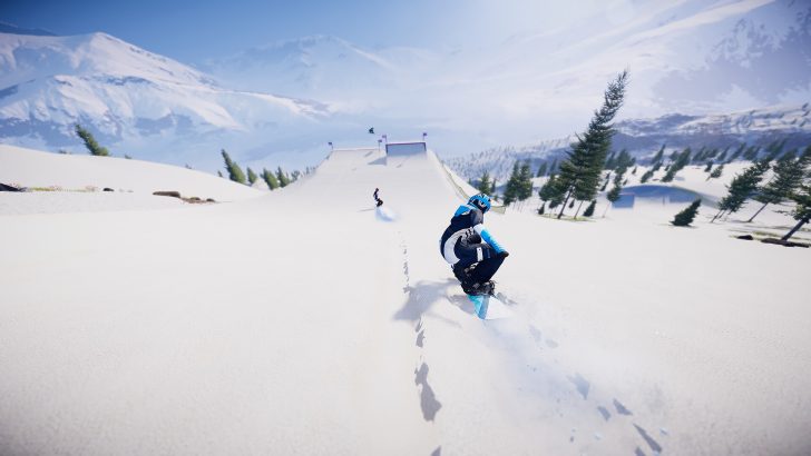 Snowboarders riding a snowy mountain slope under a clear blue sky.