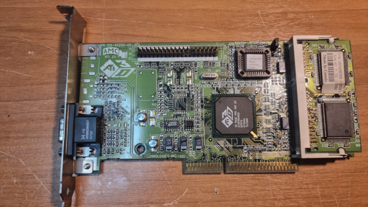 Vintage ATI graphics card on wooden surface, showing detailed microchip design and layout.