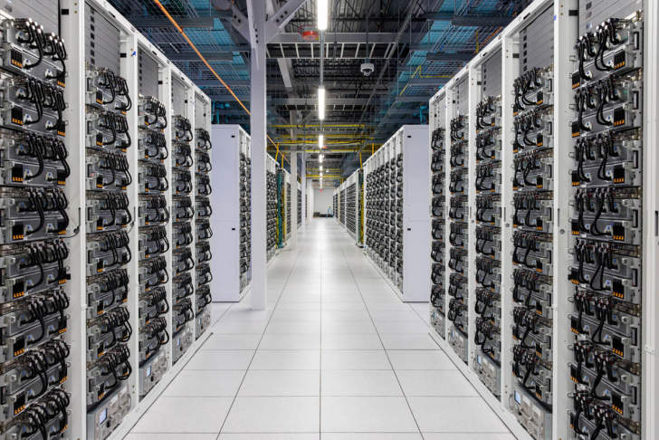 Modern data center with rows of servers in a spacious, well-lit room.