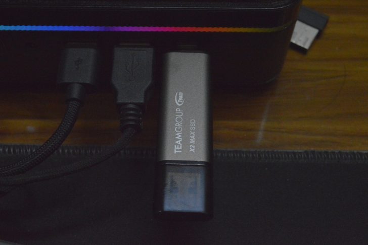 External SSD connected via USB with LED light in the background.