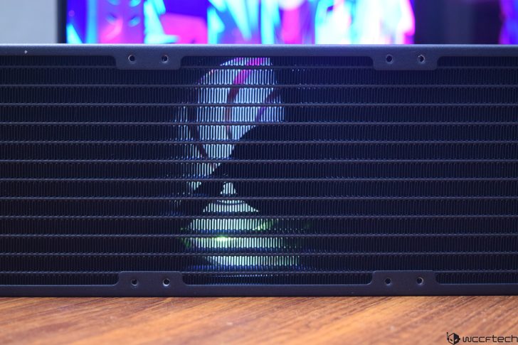 Close-up of a computer radiator with colorful reflections, showcasing cooling technology.