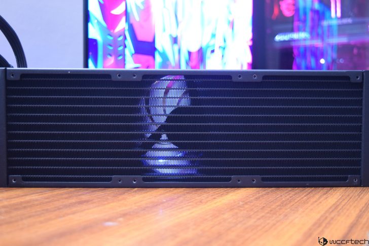 PC radiator with RGB lighting on wooden surface, colorful background display.