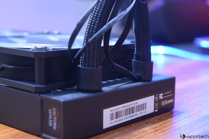 Close-up of a computer liquid cooling system on a wooden desk.