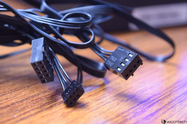 Loose computer cables with connectors on a wooden surface.