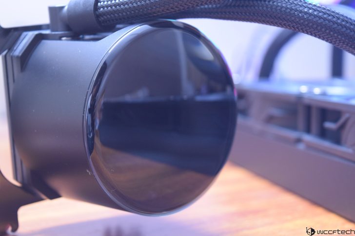Close-up of a sleek black liquid CPU cooler on a wooden surface.