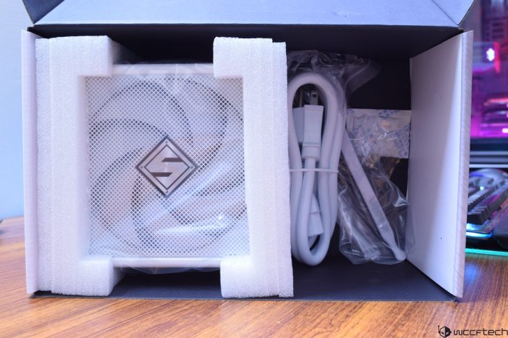 White computer fan packaged in box with accessories and cables.