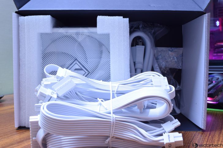 White power supply unit and cables in open box.