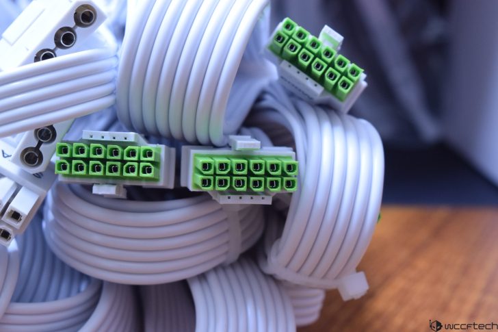 White cables with green connectors, coiled and ready for electronic installation.