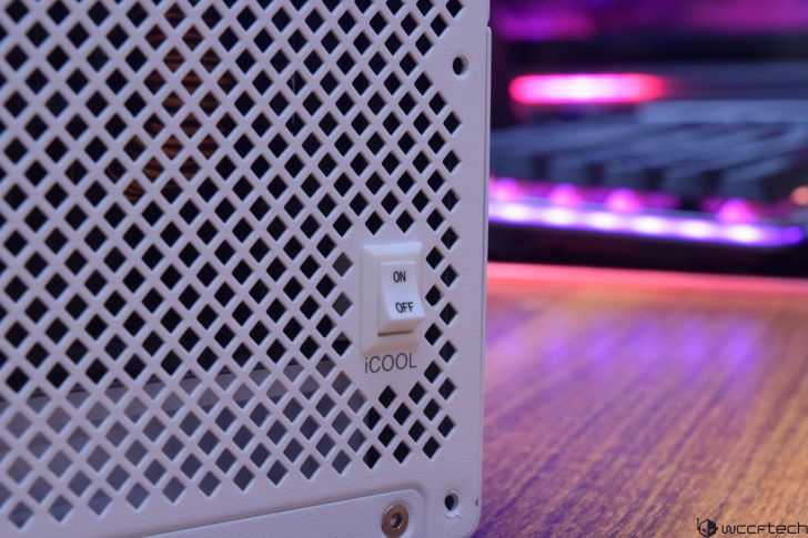 White metal grid panel with iCOOL on/off switch, blurred keyboard in background.