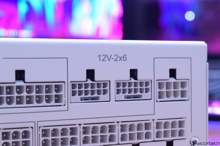 Close-up of 12V 2x6 power supply connectors on a PC component with colorful blurred background.