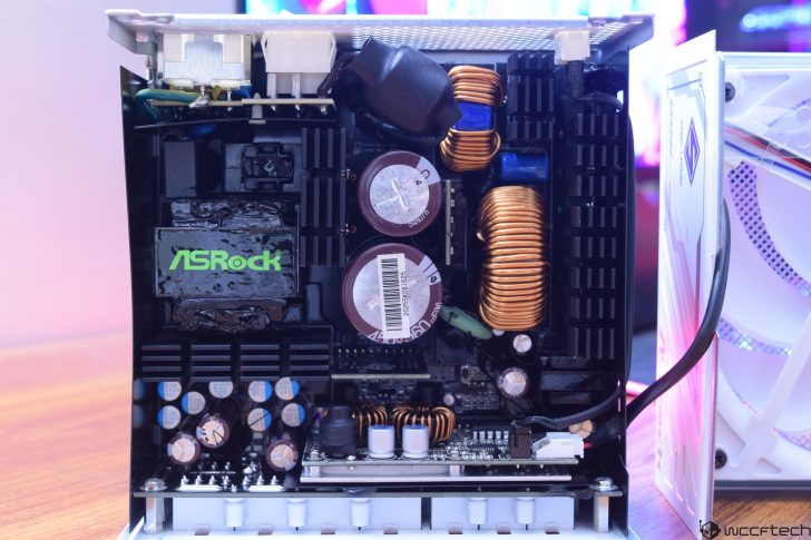 Close-up of an ASRock power supply unit, showcasing internal components and circuitry.