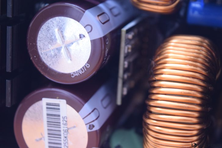 Close-up of electronic capacitors and copper coil in a circuit board.