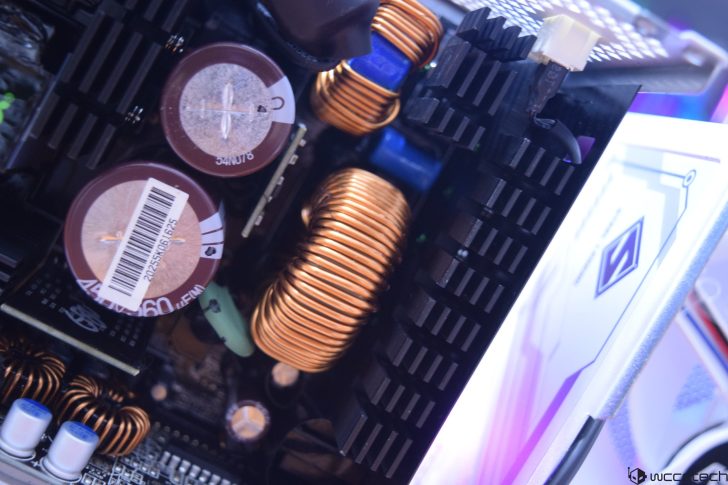 Close-up of computer motherboard with capacitors and copper coils.