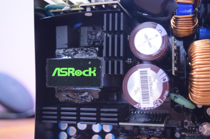 Close-up of ASRock computer components inside a power supply unit.