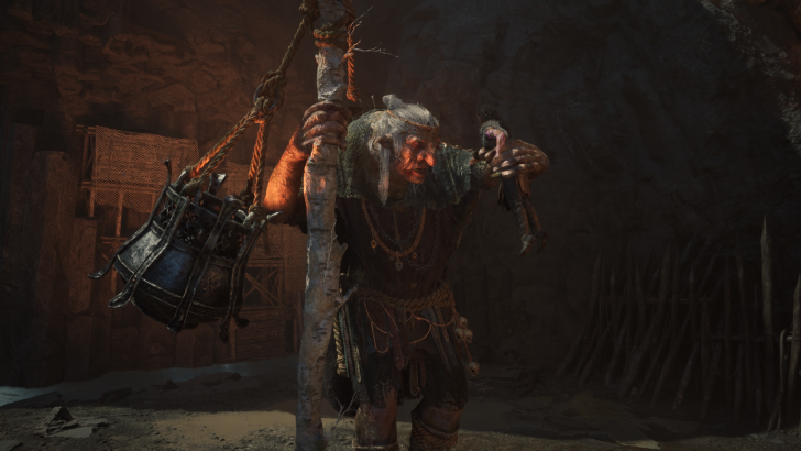 Fantasy character holding staff in cave, wearing rustic clothing and accessories.