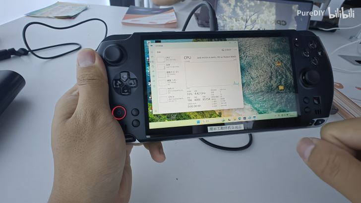 Handheld gaming device displaying CPU stats on screen in close-up view.
