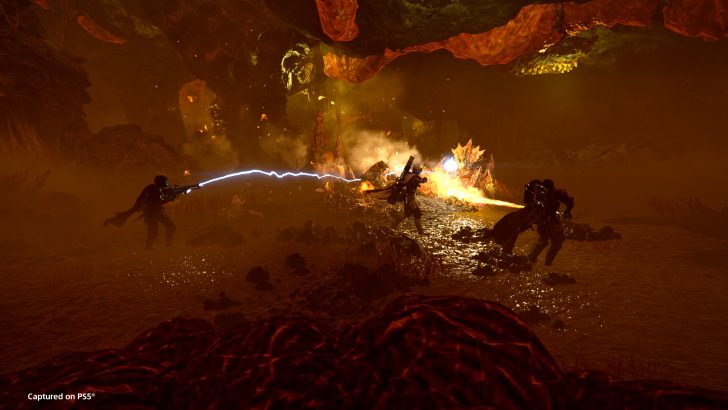 Futuristic battle in fiery alien cave, with energy weapons and dramatic lighting.