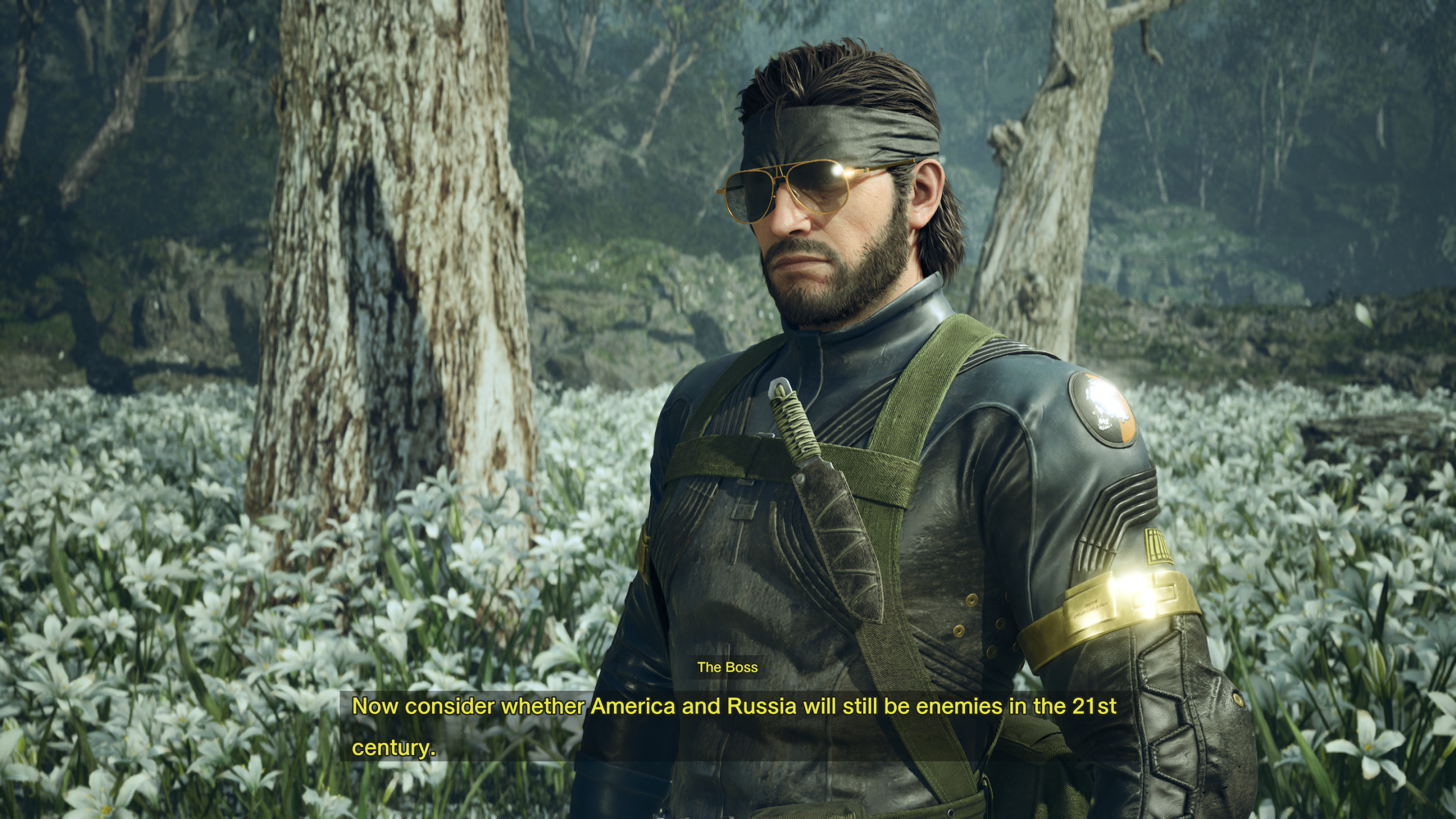 Soldier in tactical gear stands in a tranquil forest clearing surrounded by white flowers.