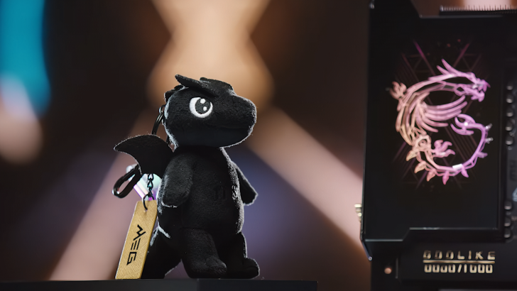 Black dragon plush keychain on display next to a glowing dragon emblem.