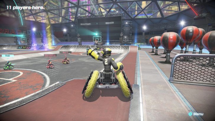 Futuristic race in vibrant arena with robotic driver in yellow suit, surrounded by balloons.