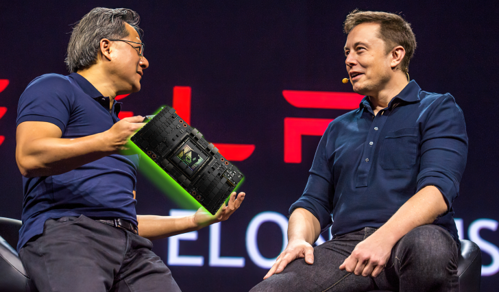 Two men discussing a tech device on stage at a conference.