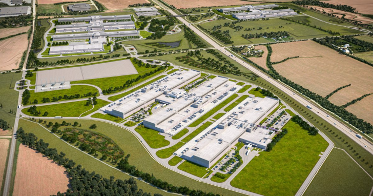 Aerial view of a large industrial complex surrounded by fields and roads.