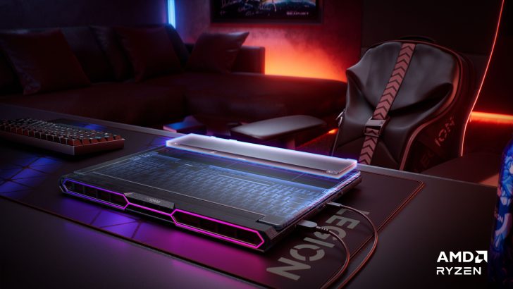 Lenovo Legion gaming laptop with AMD Ryzen logo on desk, surrounded by a keyboard and gaming chair, in a neon-lit room.