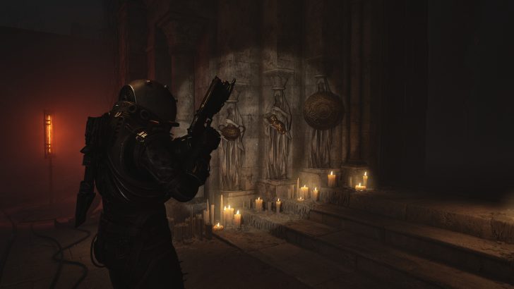 A figure in armor holds a weapon in a dimly lit room with candles and statues on stone steps.
