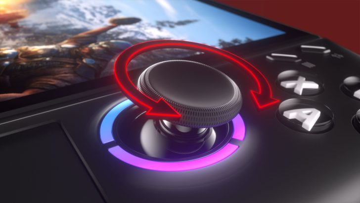 Unbranded gaming device with joystick shows red rotation arrow near screen displaying a game scene.
