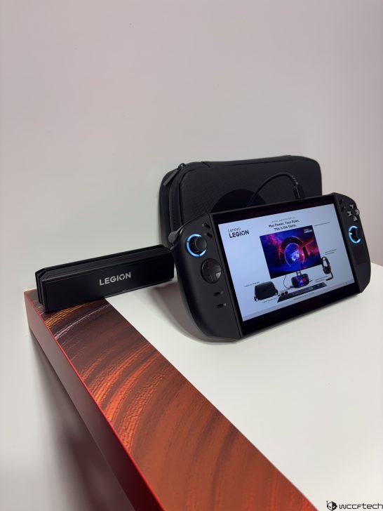 Lenovo Legion handheld gaming device on a display stand with LEGION visible on a dock, and product information on its screen.