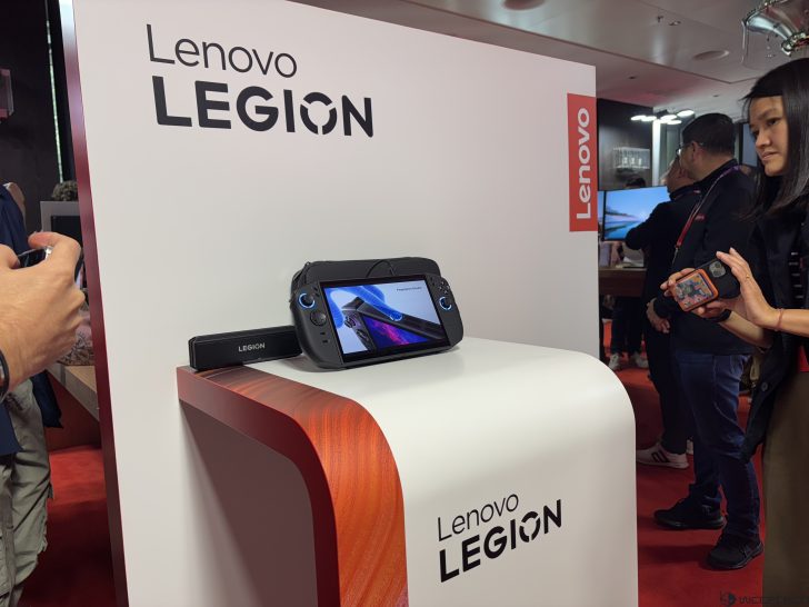 Lenovo Legion gaming handheld on display stand with Lenovo Legion branding.