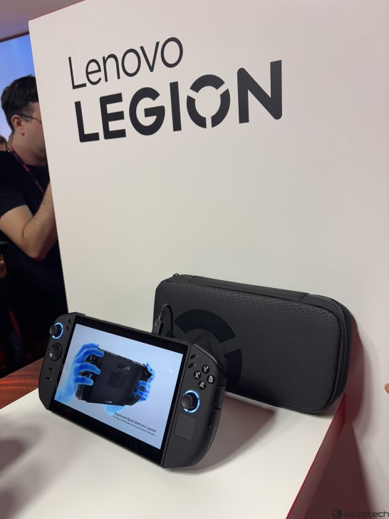 Lenovo Legion handheld device on display next to case, showing Improved Back Button Layout text on screen.