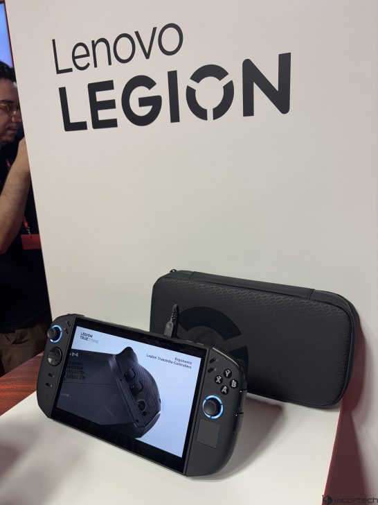 Lenovo Legion gaming handheld with Legion Truestrike on-screen text displayed on a stand.