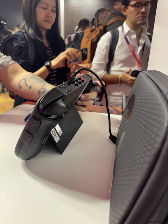 Lenovo device with controllers on display, connected and showcased in a tech event setting.
