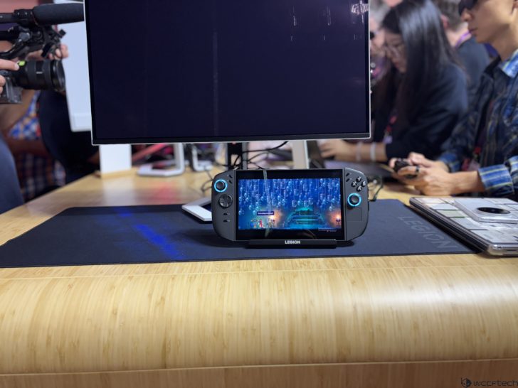 Lenovo Legion gaming handheld in use on a table in front of a monitor.