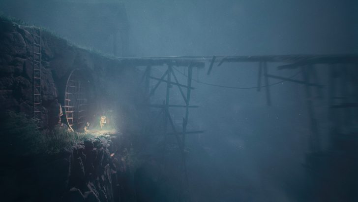 A person in an astronaut suit stands at the entrance of a tunnel with a dim light, against a foggy backdrop and wooden structure.