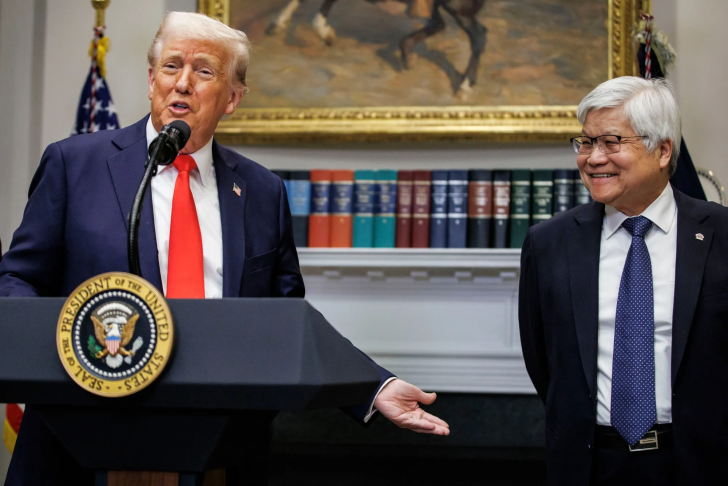 Two men standing at a podium with the Seal of the President of the United States and a bookshelf in the background.
