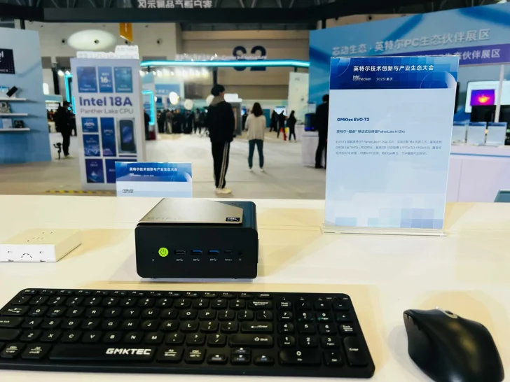 A GMKtec EVO-T2 mini PC is displayed with a GMKtec keyboard and mouse, alongside signage mentioning 'Intel 18A' and 'Panther Lake CPU.'