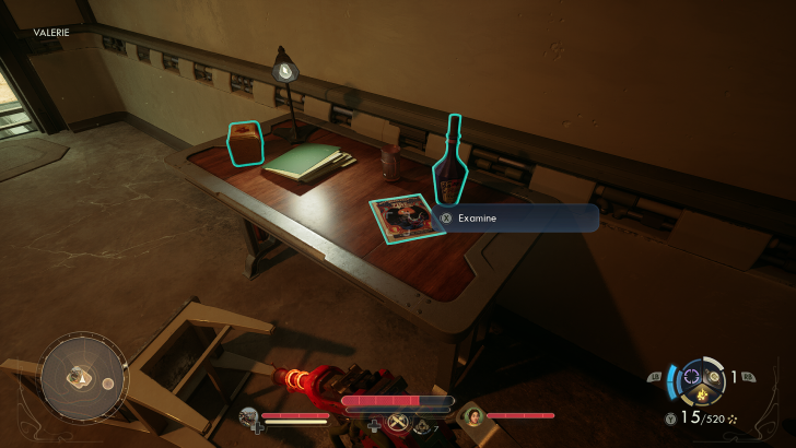 Examining a table with a bottle labeled 63 Red Rocket, a magazine, and a dim lamp in a game setting with HUD elements visible.