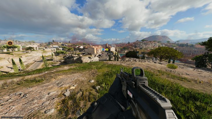 A first-person view in the game Call of Duty: Modern Warfare III, showing a player holding a rifle overlooking a sunlit village landscape with markers labeled '3' and '2'.