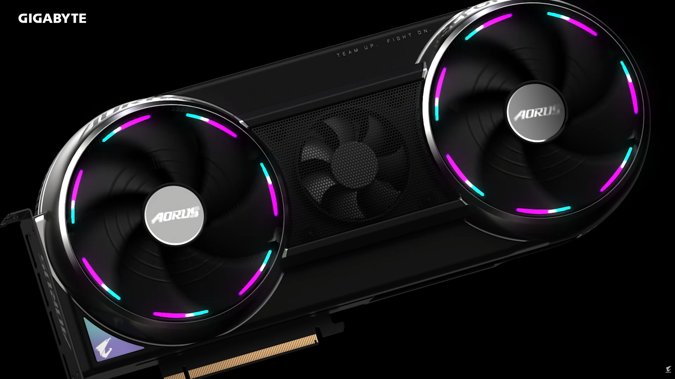A Gigabyte AORUS graphics card with two RGB-illuminated fans and the text 'TEAM UP. FIGHT ON.' on top.
